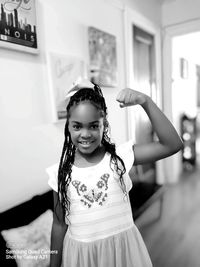 Portrait of smiling girl standing against wall