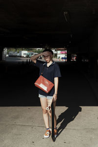 Full length of woman standing with umbrella