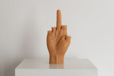 Close-up of human hand against white wall