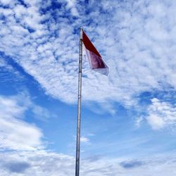 Low angle view of flag against blue sky