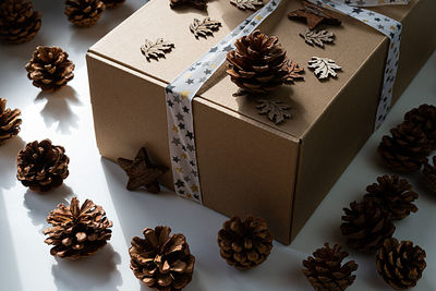 Sustainable gift with pine cones and wooden ornaments around