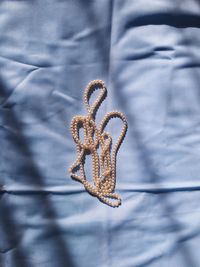 High angle view of necklace on bed
