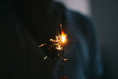 Midsection of person holding sparkler