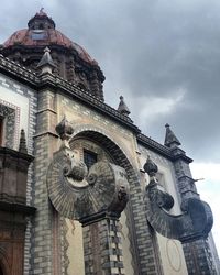 Low angle view of building against cloudy sky