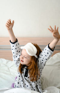 Portrait of young woman lying on bed at home