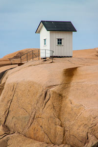 Hut on rock formation against sky