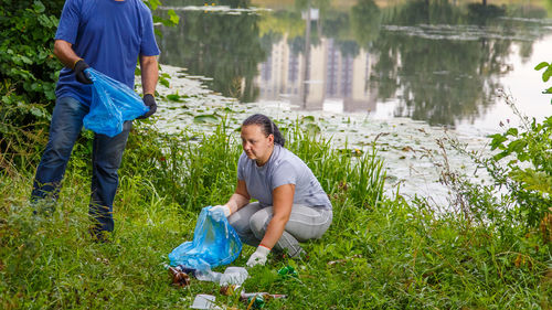 A woman and a man, a faceless volunteer, removes rubbish at a dump in nature. horizontal photo
