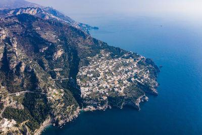 High angle view of sea and mountains against sky