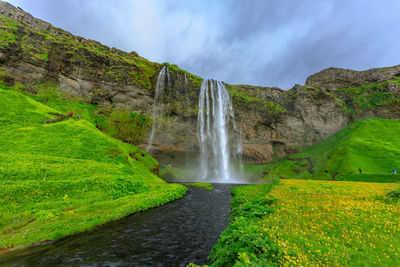 Scenic view of waterfall against sky