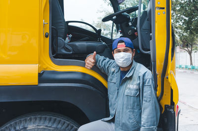 Man working on yellow car