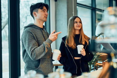 Friends doing shopping in a coffee shop. people buying coffee and sweet snacks to go