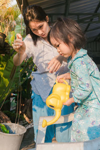 Young woman with daughter while standing outdoors