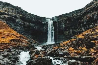 Low angle view of waterfall against clear sky