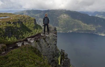 Full length of man standing on cliff against sky