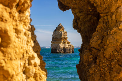 Rock formations by sea against sky