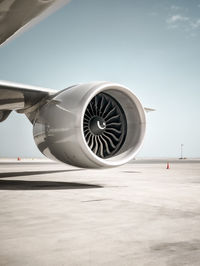 Airplane on airport runway against sky