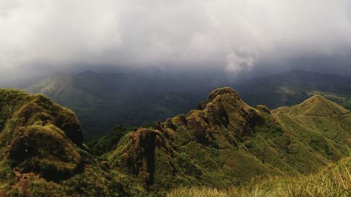 Scenic view of mountains against cloudy sky