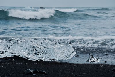 Close-up of wave on beach against sky