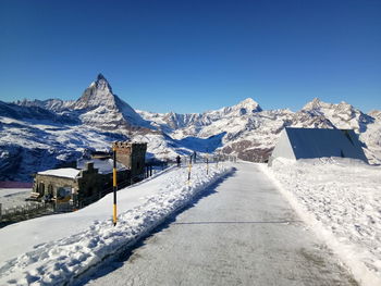 Scenic view of snowcapped mountains against clear blue sky