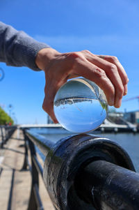 Close-up of hand holding blue sky