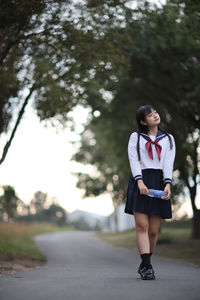 Young woman standing on road