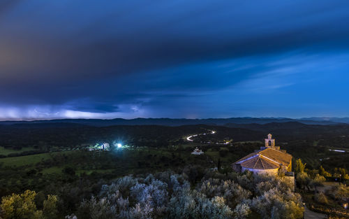 Panoramic view of trees and buildings against sky at night