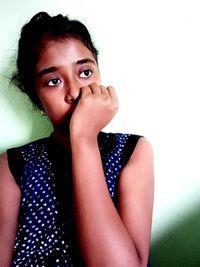 Portrait of beautiful young woman against wall