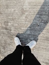 Low section of person standing on hardwood floor