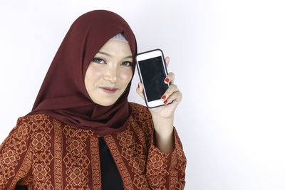 Portrait of beautiful young woman against white background