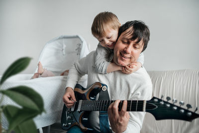 Dad plays guitar with young son