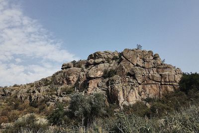 Low angle view of rock formation on land against sky