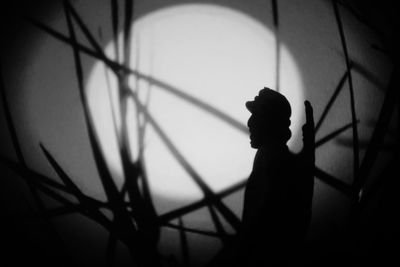 Silhouette man standing against wall at night