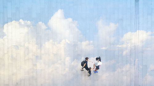 People walking on road in city against sky