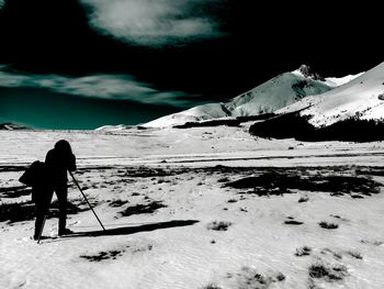 Man skiing on snowcapped mountain against sky