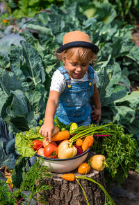 High angle view of boy standing amidst vegetables for sale