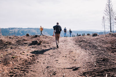 Rear view of people walking on land