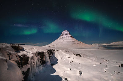 Scenic view of snowcapped mountains against sky at night