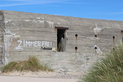 Text on wall against sky