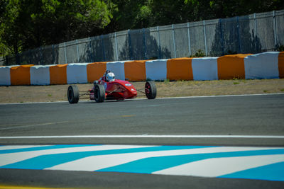 Full length of man sitting on vintage race car