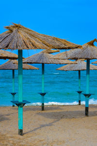 Lifeguard hut on beach against clear blue sky