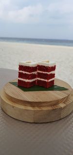 Close-up of chocolate on table at beach against sky