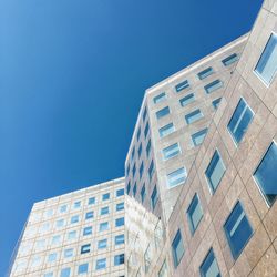 Low angle view of modern building against blue sky