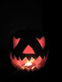 Close-up of illuminated halloween pumpkin against black background