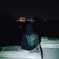 Rear view of man standing in city at night