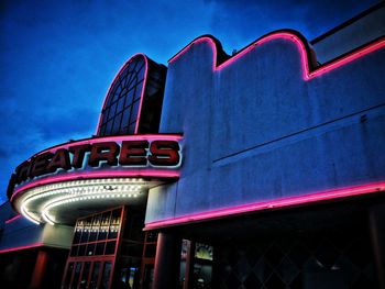 Low angle view of illuminated building against blue sky