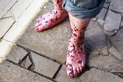 Messy low section of man standing on footpath