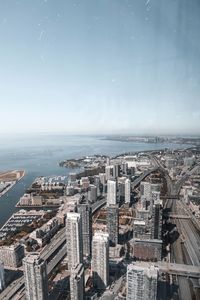 High angle view of buildings by sea against sky