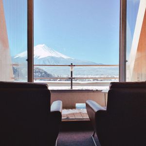 View of restaurant by sea against sky seen through glass window