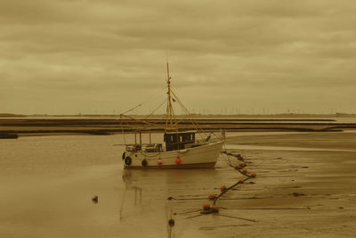 Boat moored on sea against sky