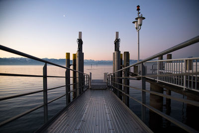 Pier over sea against sky during sunset